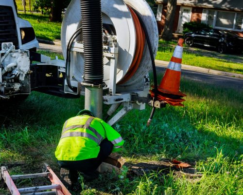 Sewage cleaning workers equipment with sewer on a town street on industrial truck